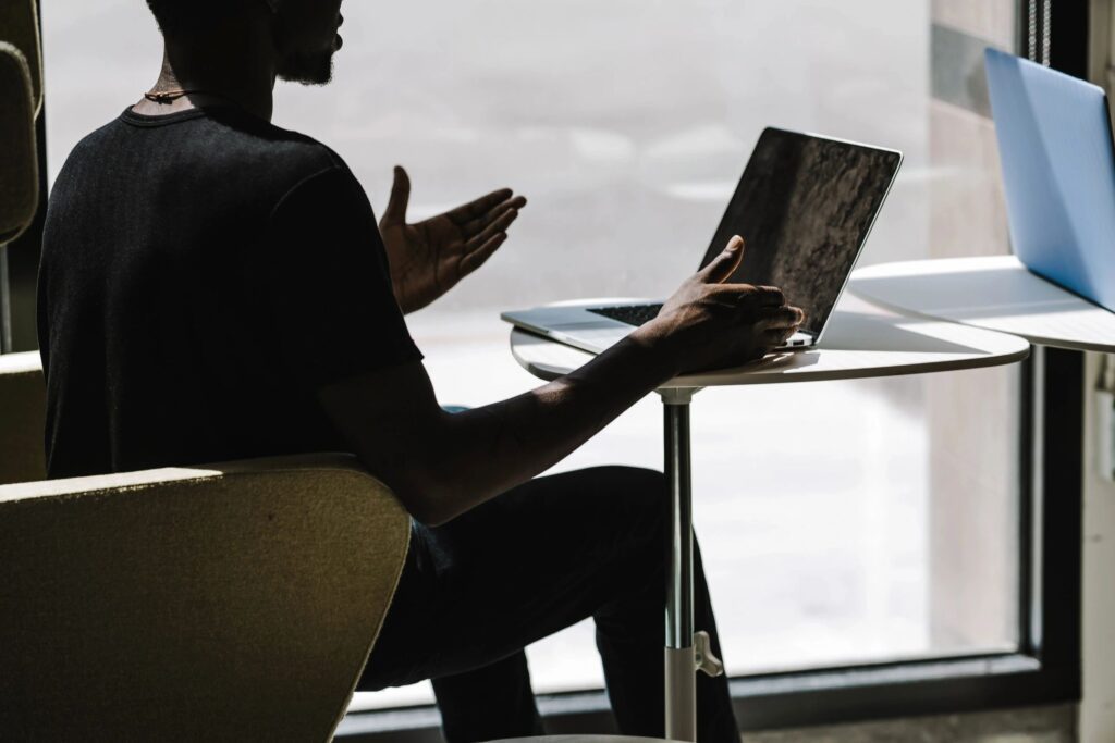 A man sitting in front of a laptop attending a meeting